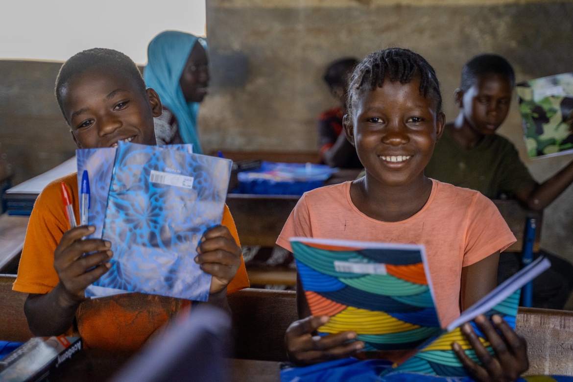 Two students proudly holding their new exercise books